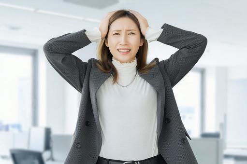 頭を抱えて困る女性・ビジネスウーマン 女性,困る,悩むの写真素材