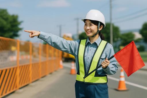 工事現場で誘導する女性作業員 工事現場で誘導する女性作業員の写真
