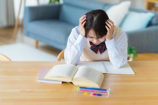 自宅で勉強中に悩む女子高生 自宅で勉強中に悩む女子高生の写真