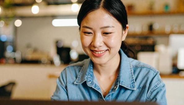 カフェでテレワークする若い日本人女性 カフェでテレワークする若い日本人女性の写真
