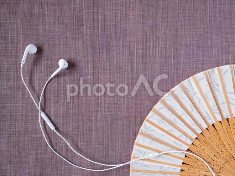 オフホワイトの扇子と白いイヤフォン紫背景 紫背景,和風,扇子の写真素材