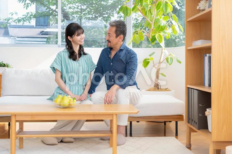 リビングでくつろぐミドルの夫婦 夫婦,家族,ミドルの写真素材