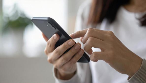 スマホを操作する女性 スマホを操作する女性の写真