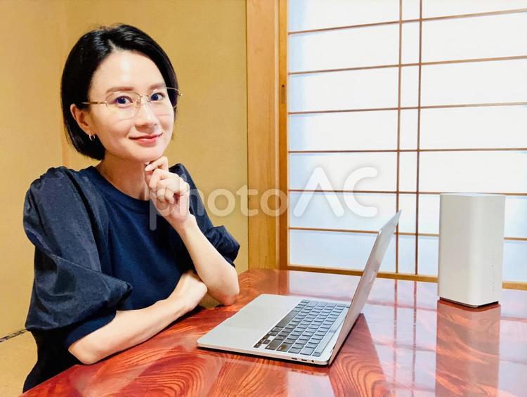 和室でリモートワークをするメガネの女性 在宅ワーク,wifi,パソコンの写真素材