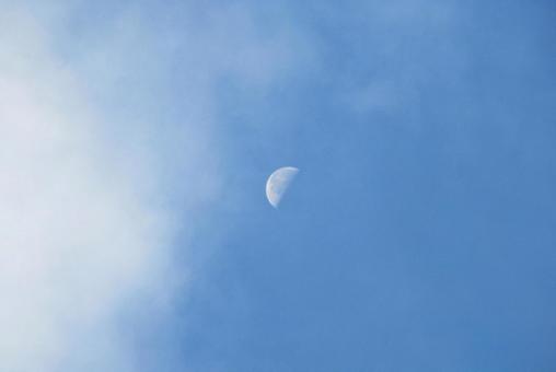 白い雲と下弦の月の写真