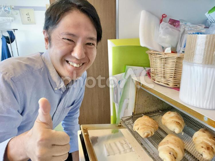パンをトースターで焼く男性 パン,男性,クロワッサンの写真素材