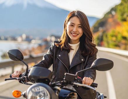 バイクに跨がる若くて美しい女性 バイクに跨がる若くて美しい女性の写真