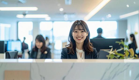 笑顔で対応する女性の受付嬢 笑顔で対応する女性の受付嬢の写真