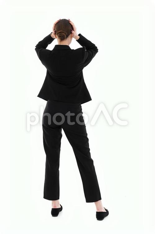 頭を抱えるスーツ女性の後ろ姿 女性,後ろ姿,立つの写真素材