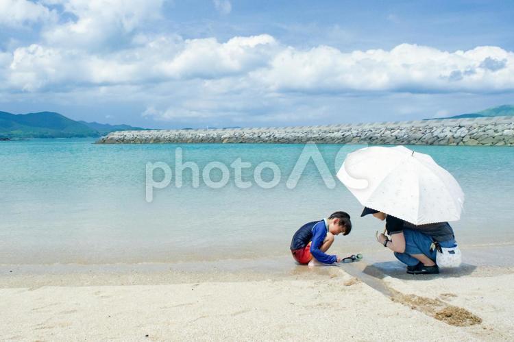R＜素材＞夏の海で子供が遊ぶ姿を見守る母 家族,子供,女性の写真素材