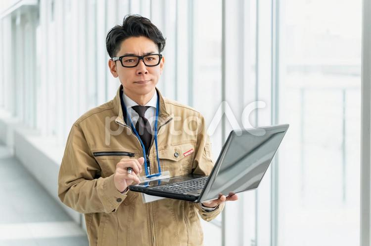 怒った顔で見てくる作業服の男性 ビジネス,ビジネスマン,作業員の写真素材