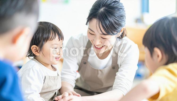 保育園で子供と遊ぶ笑顔の保育士の女性 保育士,女の子,子供の写真素材