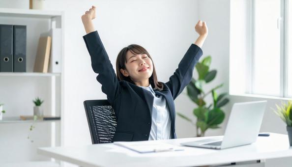 仕事が終わり達成感で背伸びをする社員 仕事が終わり達成感で背伸びをする社員の写真
