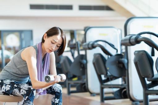 ジムでトレーニングするミドルの女性 ジム,女性,ダンベルの写真素材