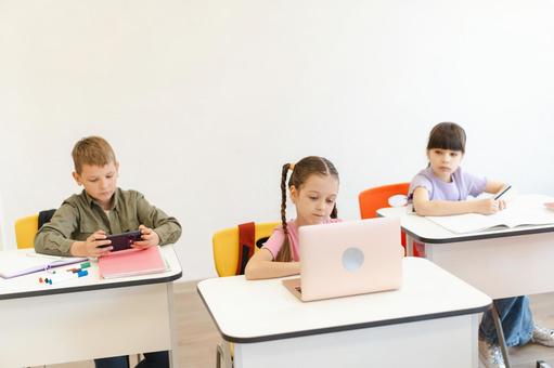 パソコンを見たり携帯を見る生徒たち 男の子,女の子,子どもの写真素材