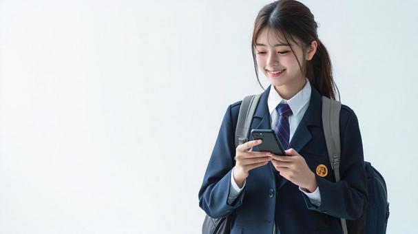 歩きながらスマートフォンを使う女子生徒 歩きながらスマートフォンを使う女子生徒の写真