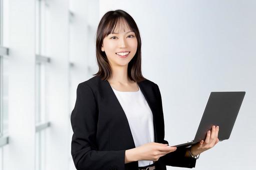 パソコンを持つ女性・ビジネスウーマン パソコンを持つ女性・ビジネスウーマン 女性,パソコン,笑顔の写真素材