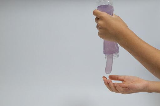 グラスから流れ落ちるスライムと手 スライム,グラス,手の写真素材