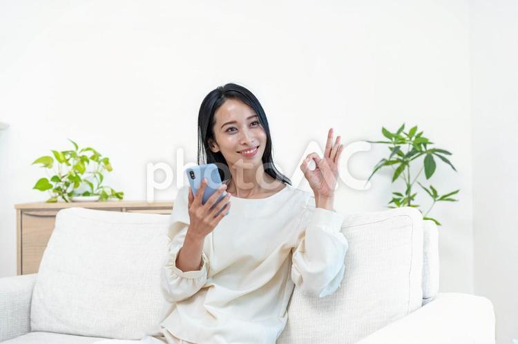 携帯を持ち案内をする日本人女性 スマホ,検索,アプリの写真素材