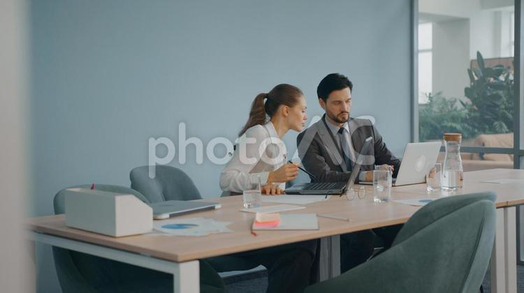 会議室のテーブルでノートパソコンを使う男女 コワーキング,ビジネス,女性の写真素材