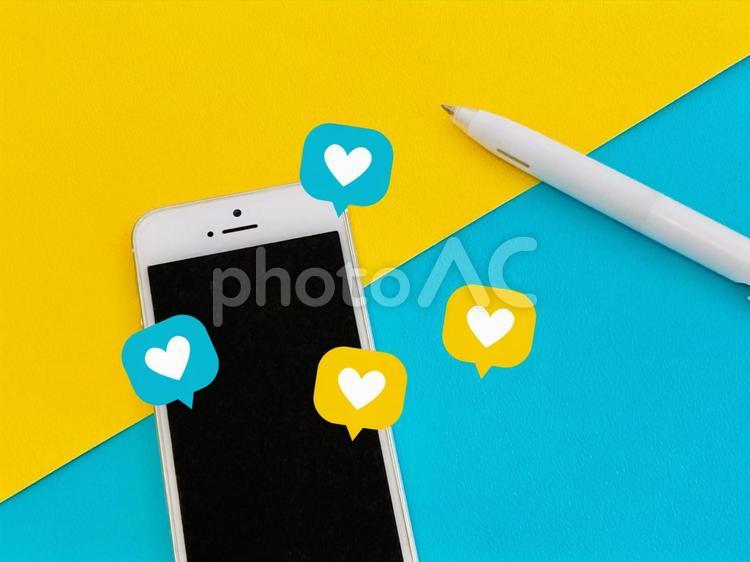 スマホとハートのアイコン（黄色とブルー） スマホ,sns,いいねの写真素材