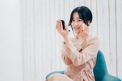 笑顔でメイクをする若い女性 デート,リップ,化粧品の写真素材