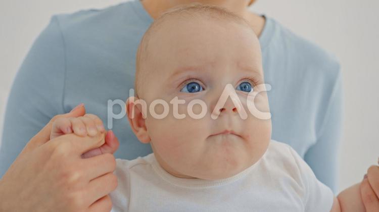 大人の指を握る碧眼の赤ちゃん 赤ちゃん,かわいい,顔の写真素材
