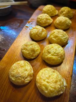 ふわふわ明石焼きが木の板に並ぶ和食の一皿 ふわふわ明石焼きが木の板に並ぶ和食の一皿の写真