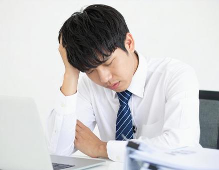 オフィスで困っているサラリーマン男性 オフィスで困っているサラリーマン男性の写真