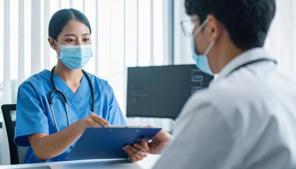 手術前に患者に手術同意書を渡す医師 手術前に患者に手術同意書を渡す医師の写真