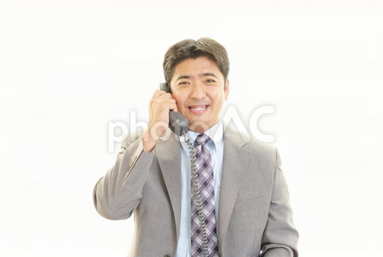 受話器を持つ笑顔のビジネスマン 男性,ビジネスマン,男の写真素材