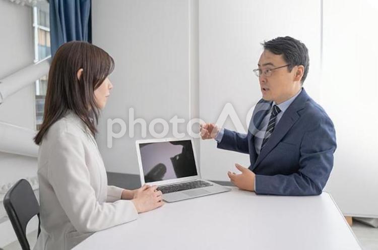 オフィスでノートパソコンを見ながら打ち合わせをする男女のビジネスマン 男性,女性,ビジネスマンの写真素材