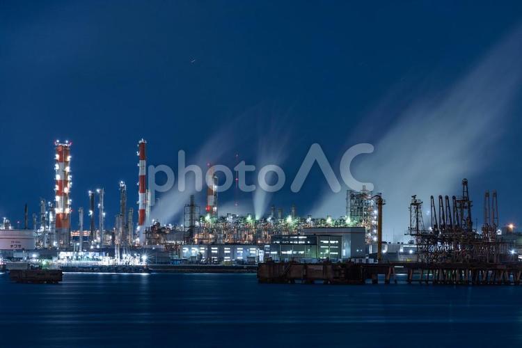 水蒸気を吐く海沿いの工場夜景 工場夜景,工場,夜景の写真素材