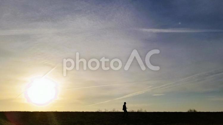 夕景の中を散歩する男性 男性,夕景,空の写真素材