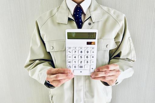 電卓を持つ作業着姿のミドル男性 見積り,作業員,男性の写真素材