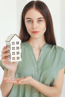 家の模型をアピールする女性 保険業,事務職,接客業の写真素材