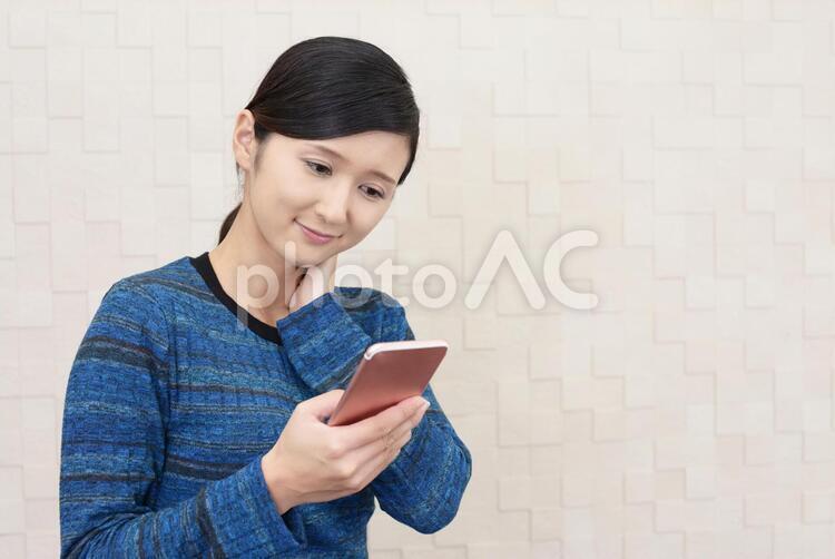 スマートフォンを持つ笑顔の女性 女性,スマートフォン,女の写真素材