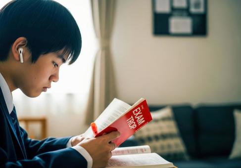 真剣に参考書を読む男子学生 真剣に参考書を読む男子学生の写真