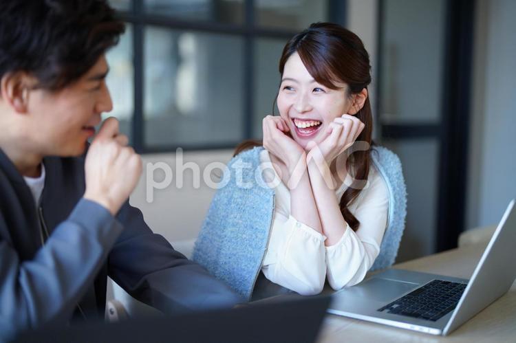 頬杖をして男性を見て笑う女性 男女,頬杖,笑顔の写真素材
