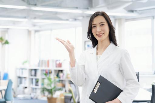 実験をする白衣の若い女性研究者 実験をする白衣の若い女性研究者の写真