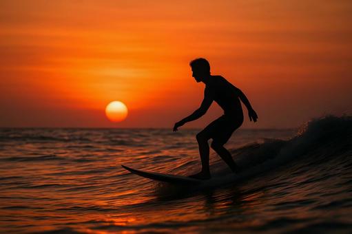 夕日に浮かぶサーファー 夕日に浮かぶサーファーの写真