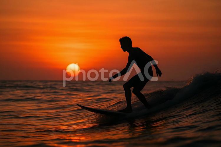 夕日に浮かぶサーファー サーフィン,サーファー,シルエットの写真素材
