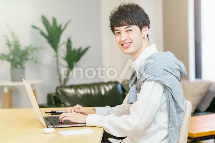 カジュアルな服装でノートPCを使う男性  男性,フリーアドレス,ビジネスの写真素材
