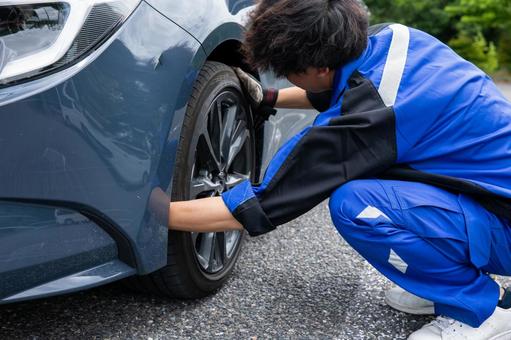 タイヤ交換する整備士の男性 タイヤ交換する整備士の男性 車,作業着,作業服の写真素材