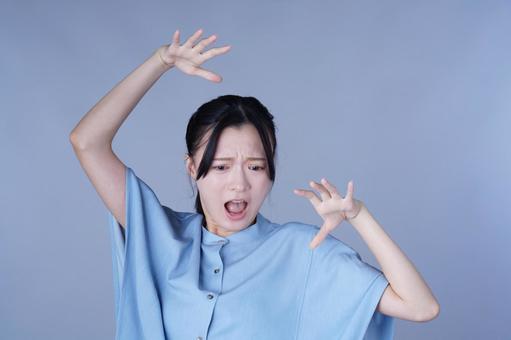 両手をあげた青い服の女性の写真