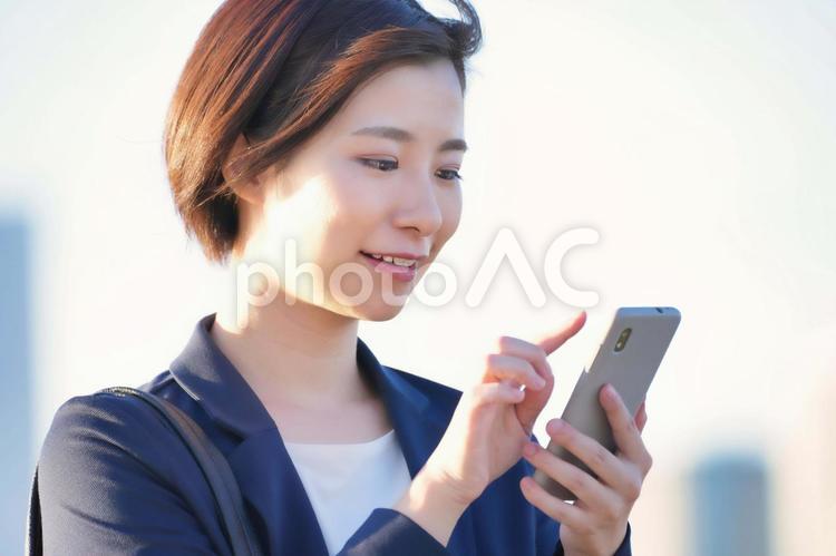 指でスマホを操作している女性 女性,ビジネス,ビジネスウーマンの写真素材