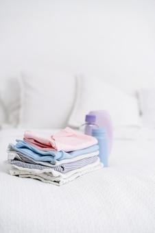 畳んで置かれたベビー服などのアイテム 畳んで置かれたベビー服などのアイテム ベビー用品,人物無し,物撮りの写真素材