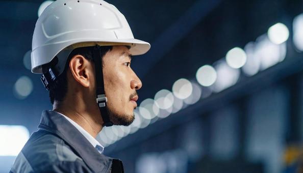 ヘルメットをかぶった作業服の男性の横顔 ヘルメットをかぶった作業服の男性の横顔の写真