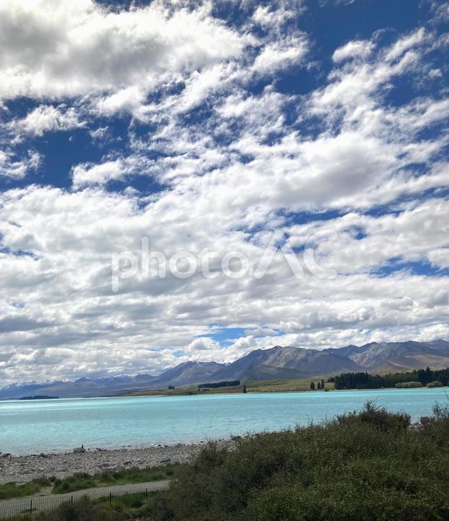 美しいミルキーブルーの湖と白くたなびく雲２（ニュージーランド） 雄大,大自然,湖の写真素材
