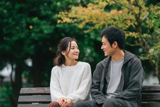 公園でくつろぐ若い男女 公園でくつろぐ若い男女の写真